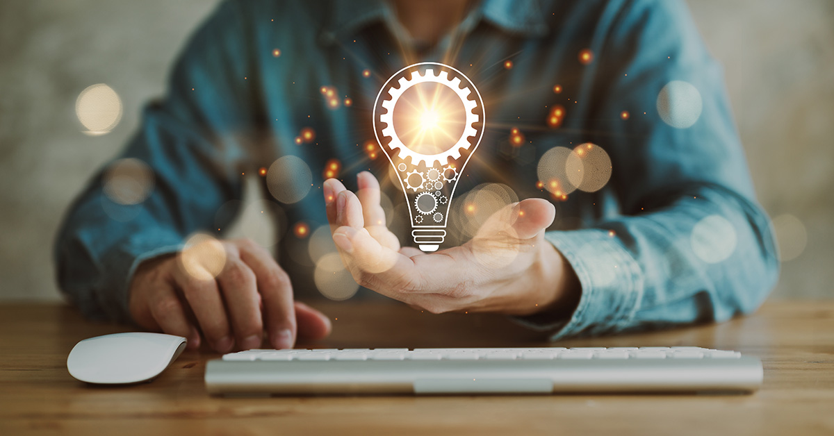 unidentifiable man in front of keyboard with palm open holding a graphic of a lightbulb